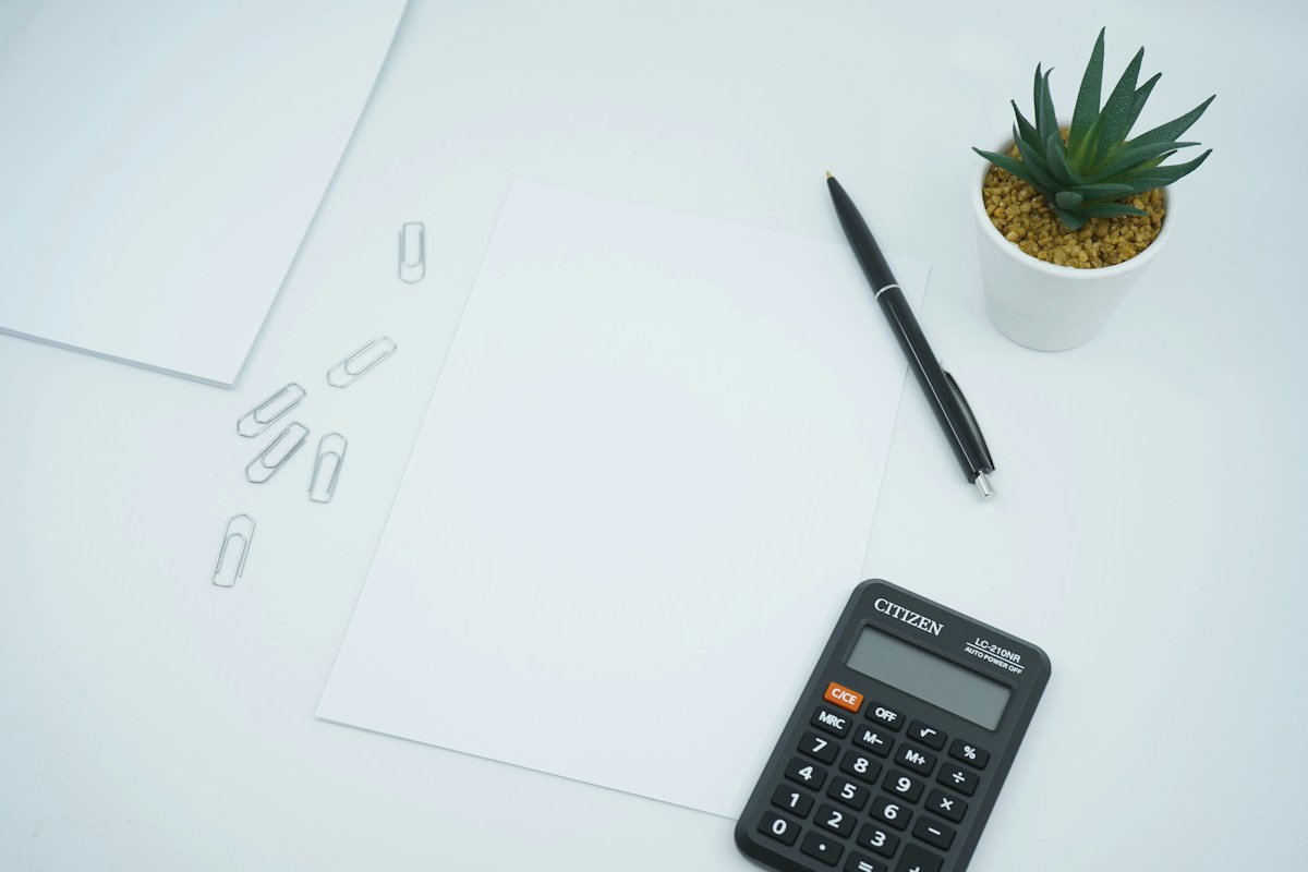 Rekenmachine, papier en pen voor het vergelijken van vastgoedkosten