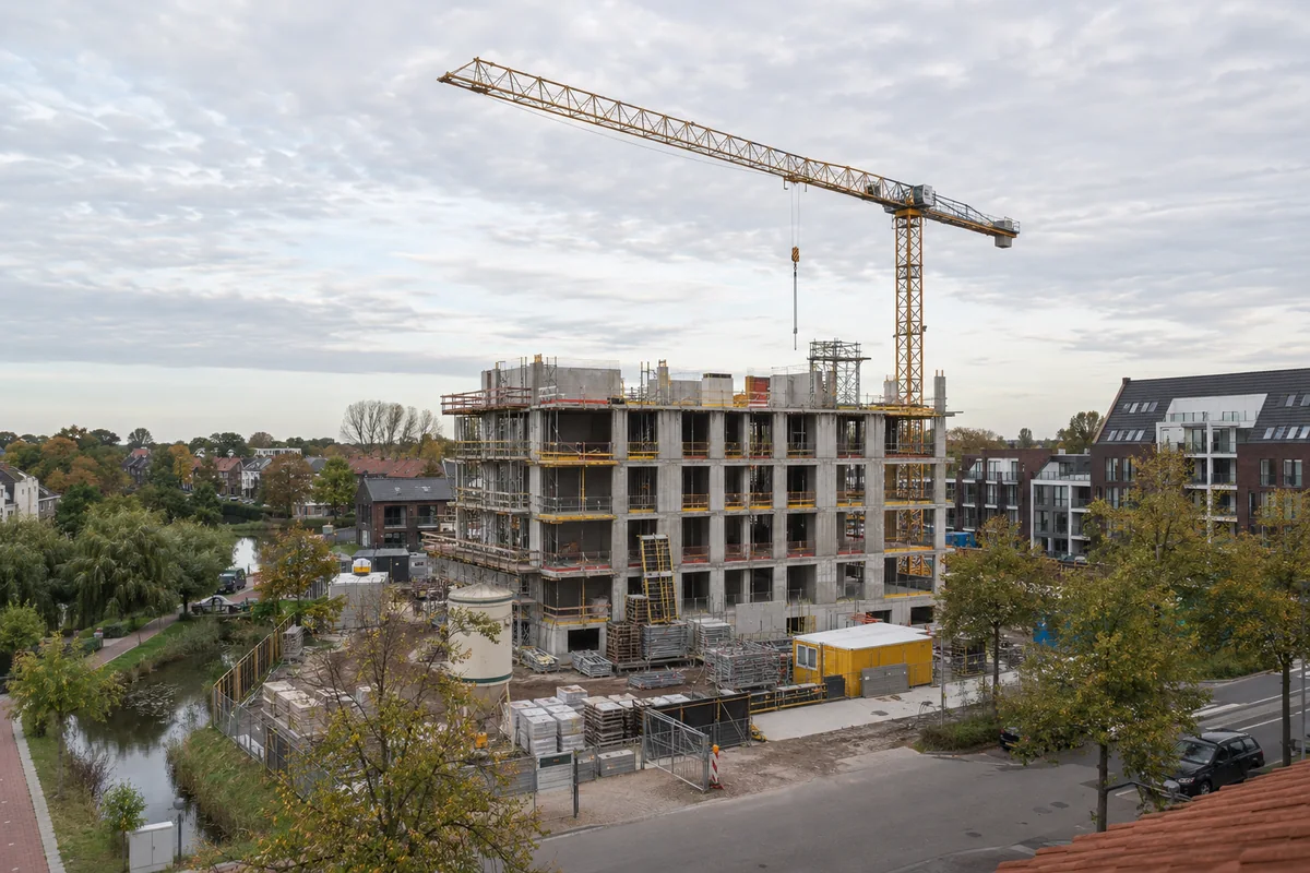 Nederlands woningbouwproject in aanbouw met een hijskraan